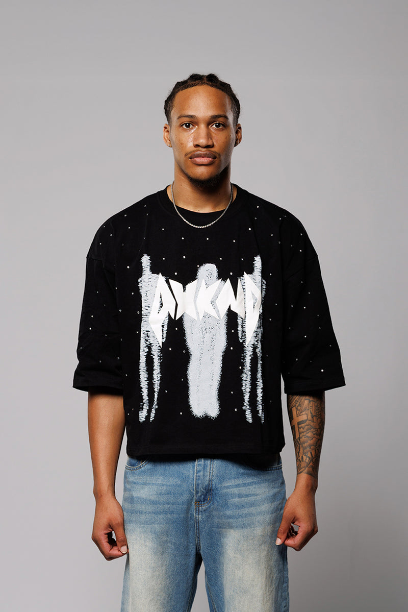 Person wearing a black sweater with white graphic design on a gray background